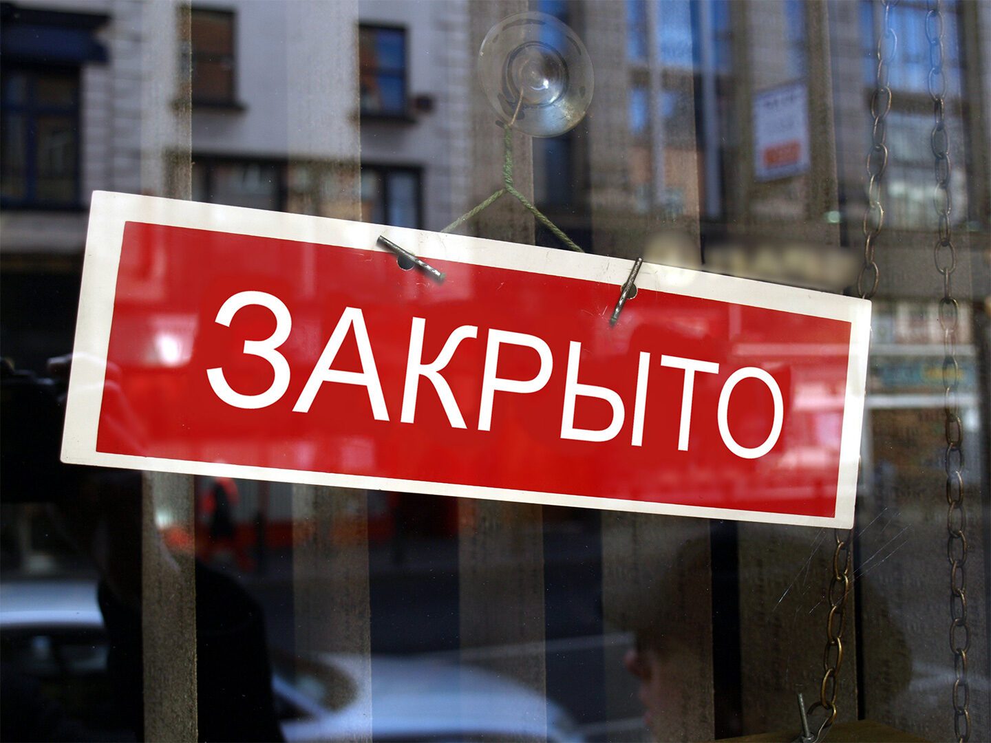 An einer Scheibe hängt ein Schild mit russischen Schriftzeichen.