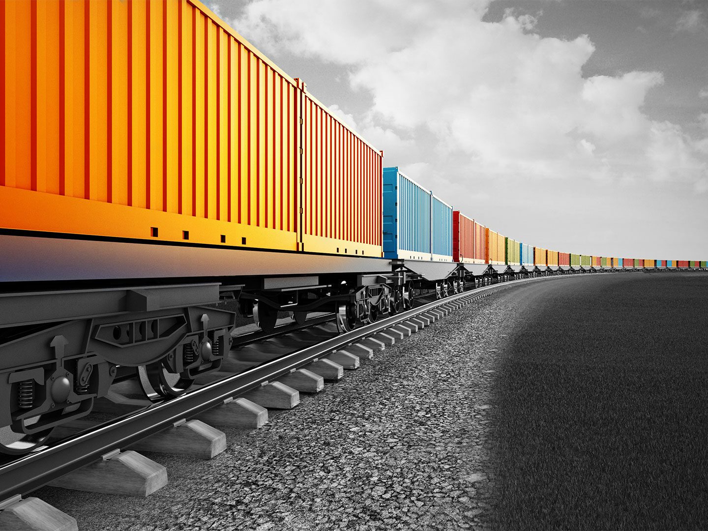 Ein Zug mit Containern mit Rohstoffen. Die Container sind bunt, der Himmel, der Boden und die Schienen sind schwarz und weiß.