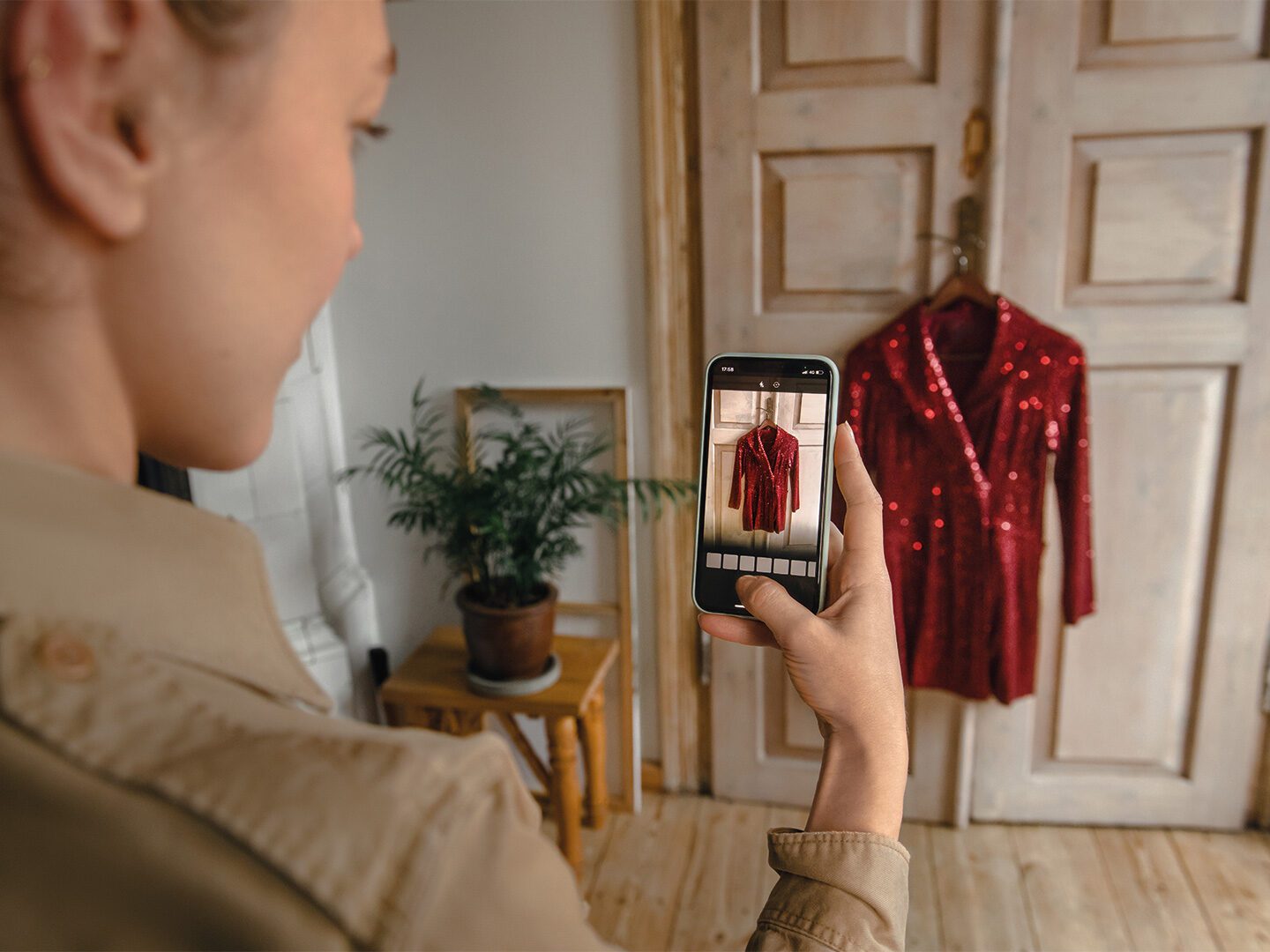 Frau fotografiert Kleid für Verkauf auf einer Plattform für Secondhand-Mode