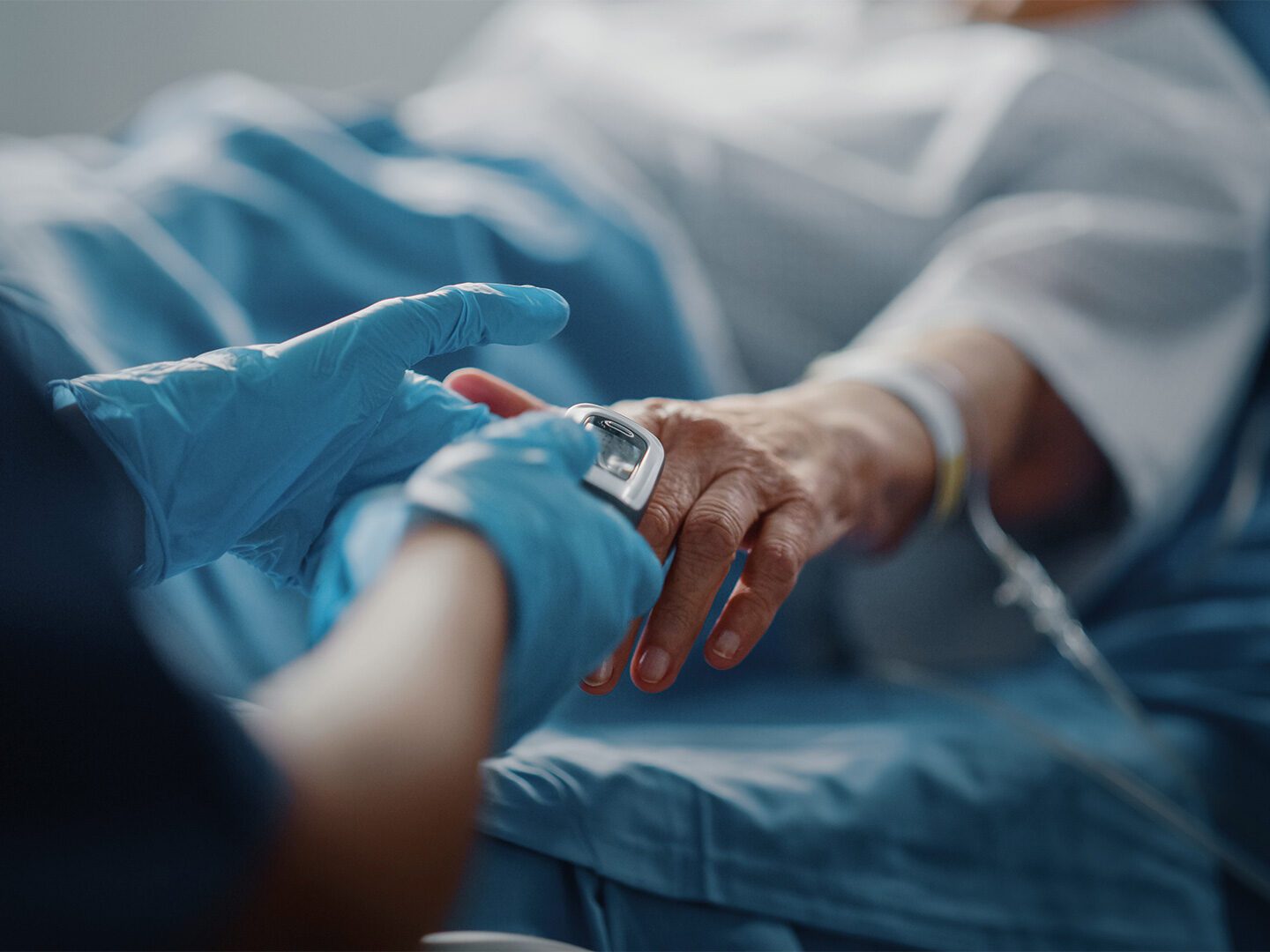 Eine Pflegekraft im Krankenhaus misst die Sauerstoffsättigung bei einem Patienten