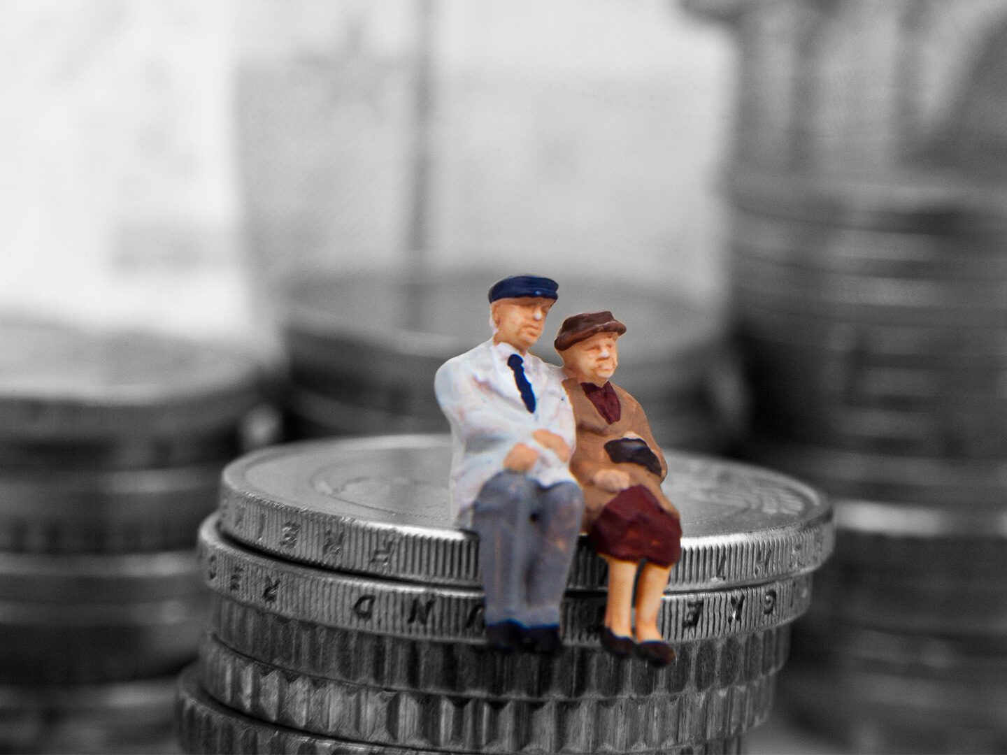 ein älteres Ehepaar sitzt auf einem Stapel Münzen