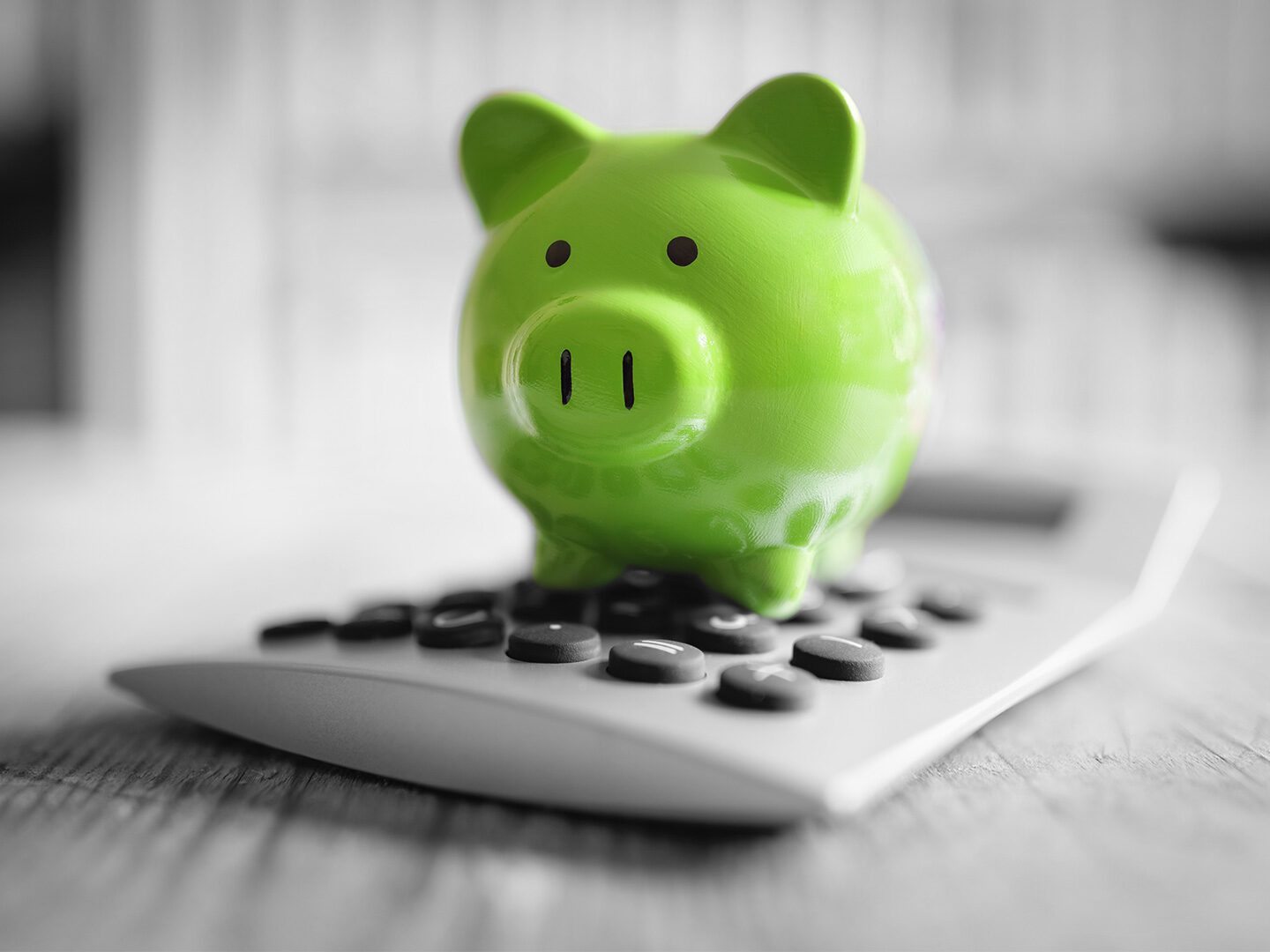 Symbolbild Steuern sparen: Grünes Sparschwein steht auf einem Taschenrechner