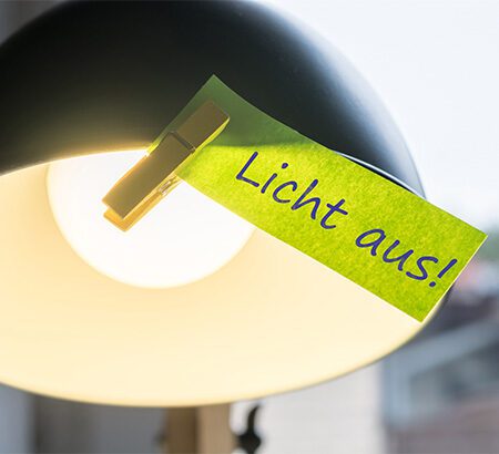 Ein Zettel am Lampenschirm animiert zum Energie sparen im Unternehmen