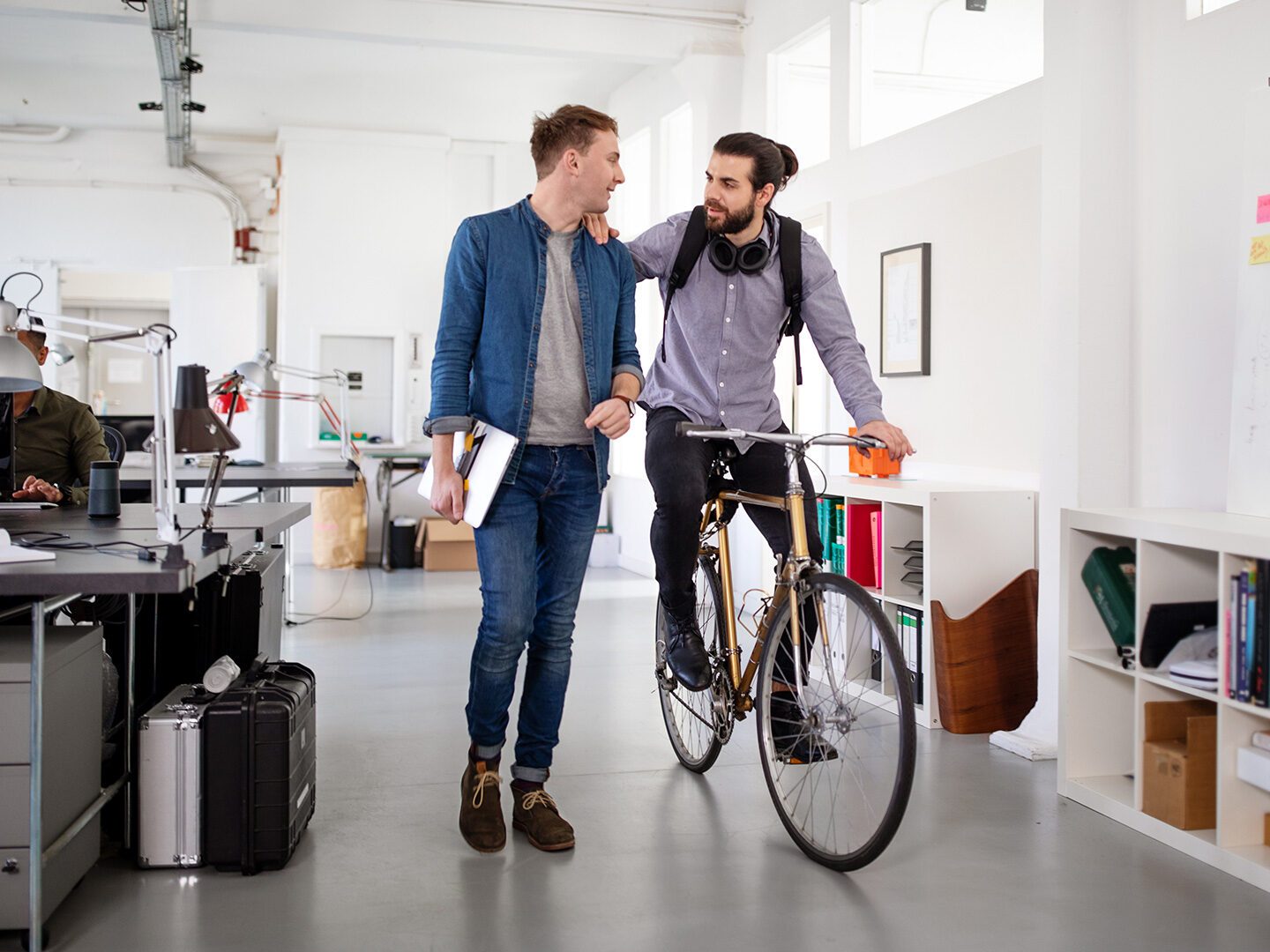 Büroangestellte mit Fahrrad, die von Benefits ihres Arbeitgebers profitieren