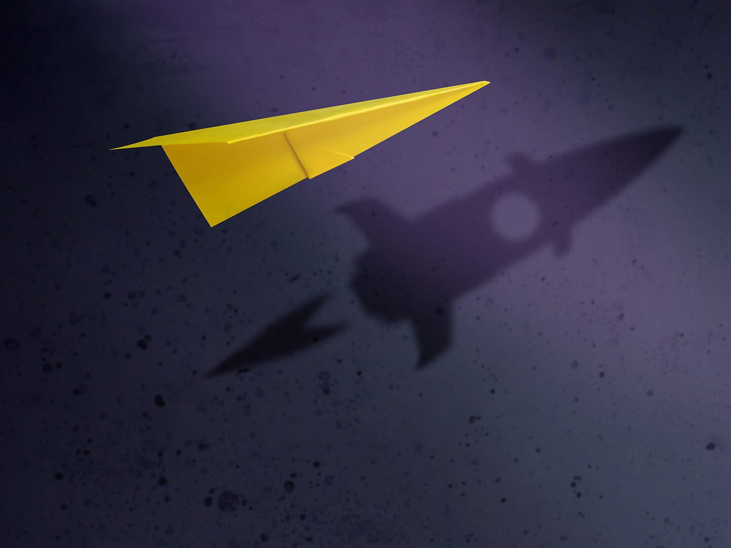 eine Rakete ist im Schatten eines gelben Papierfliegers zu sehen; Symbolbild für Wachstum trotz Krise
