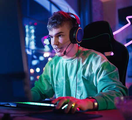 Ein junger Mann sitzt vor einem Gaming-Computer und spielt Esports.